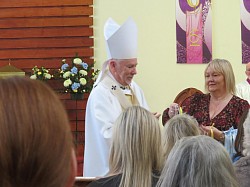Archbishop Nolan presenting gifts to Parishioners